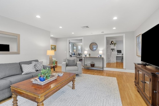 living area featuring visible vents, recessed lighting, light wood-style flooring, and baseboards