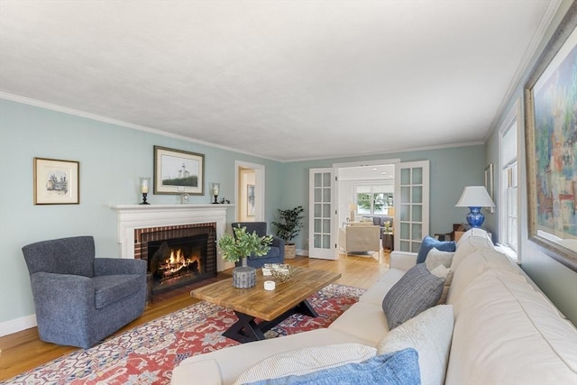 living area with crown molding, french doors, baseboards, a fireplace, and wood finished floors