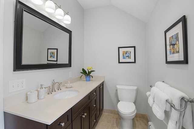 half bathroom with baseboards, vaulted ceiling, toilet, and vanity