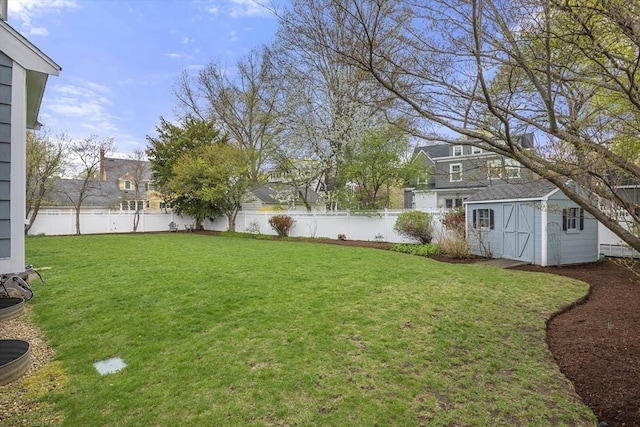 view of yard with an outdoor structure, a shed, and a fenced backyard