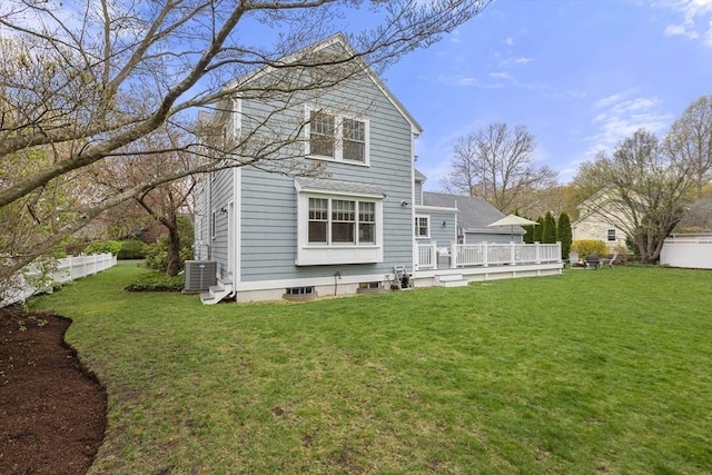 back of property with a wooden deck, a yard, and central AC unit