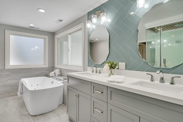 bathroom with vanity, a bathing tub, and tile walls