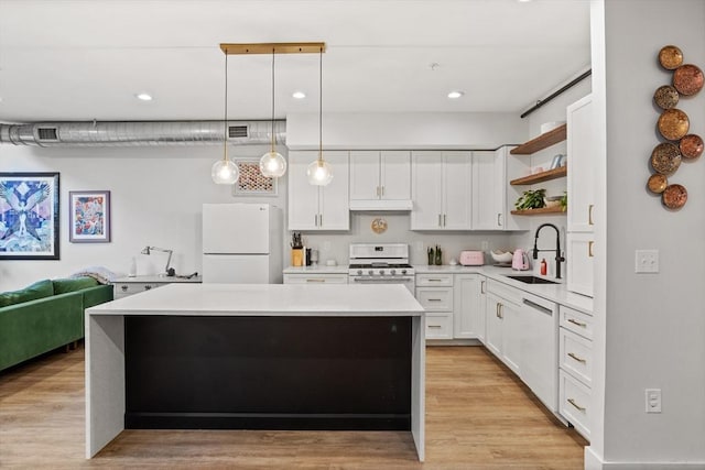 kitchen with decorative light fixtures, white cabinetry, sink, white appliances, and light wood-type flooring