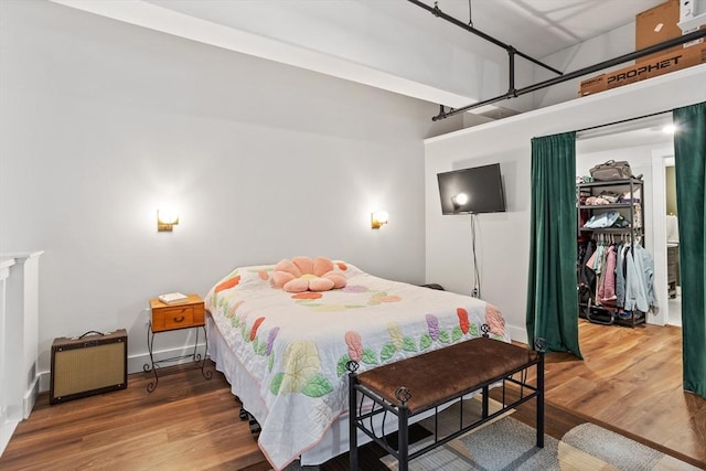 bedroom with hardwood / wood-style floors and a walk in closet