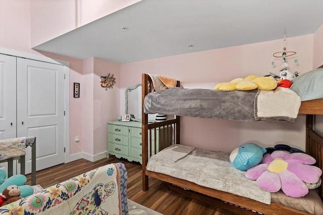 bedroom with dark hardwood / wood-style flooring and a closet