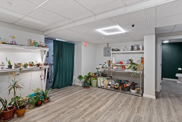 interior space with hardwood / wood-style flooring, a paneled ceiling, and electric panel