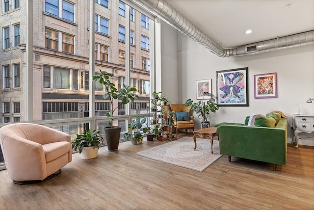 sitting room featuring a towering ceiling and light hardwood / wood-style floors