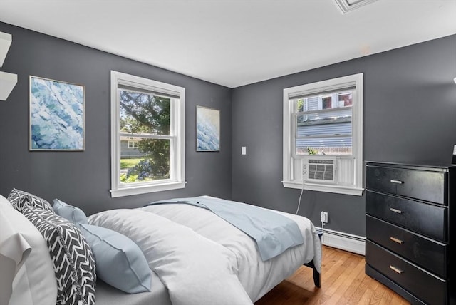 12 Day St, Fairhaven, MA 02719 - bedroom featuring baseboard heating, multiple windows, light wood finished floors, and cooling unit