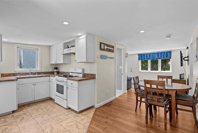 12 Day St, Fairhaven, MA 02719 - kitchen with white range with gas cooktop, dark countertops, recessed lighting, white cabinetry, and under cabinet range hood