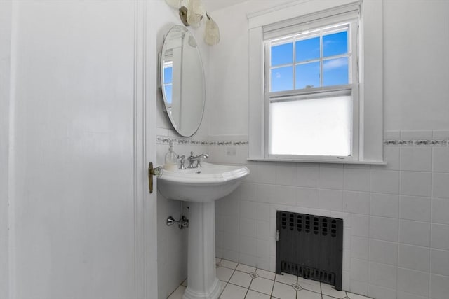 bathroom with tile patterned floors, tile walls, and radiator heating unit