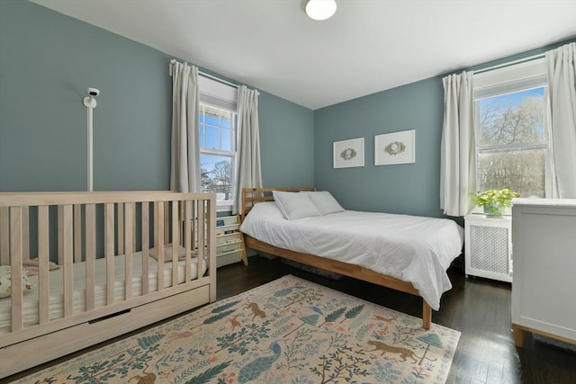 bedroom with radiator and dark hardwood / wood-style flooring