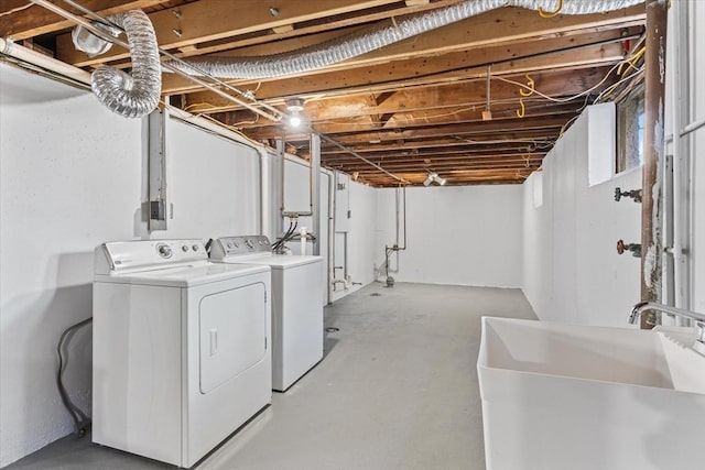 clothes washing area with laundry area, a sink, and washing machine and clothes dryer