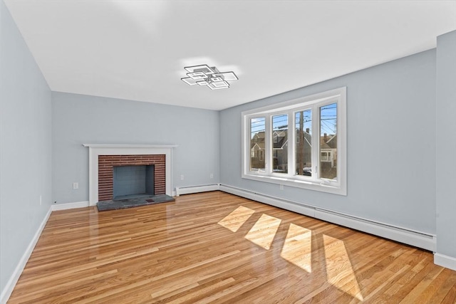 unfurnished living room featuring a brick fireplace, light wood finished floors, a baseboard radiator, and baseboards