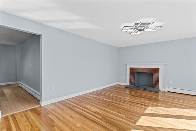 unfurnished living room with light wood-style floors, a baseboard radiator, a brick fireplace, and baseboards