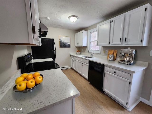 kitchen featuring white cabinets, a sink, light wood finished floors, and black appliances