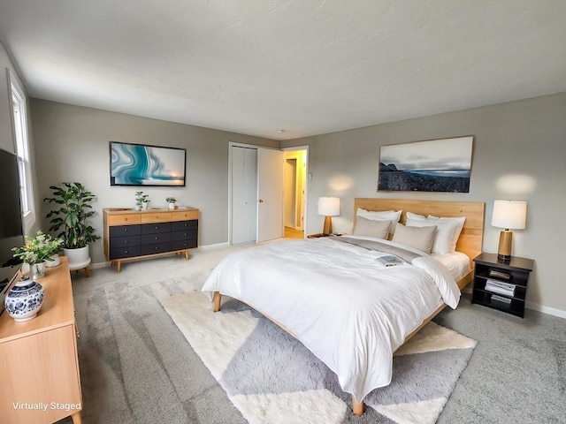 carpeted bedroom with a closet and baseboards