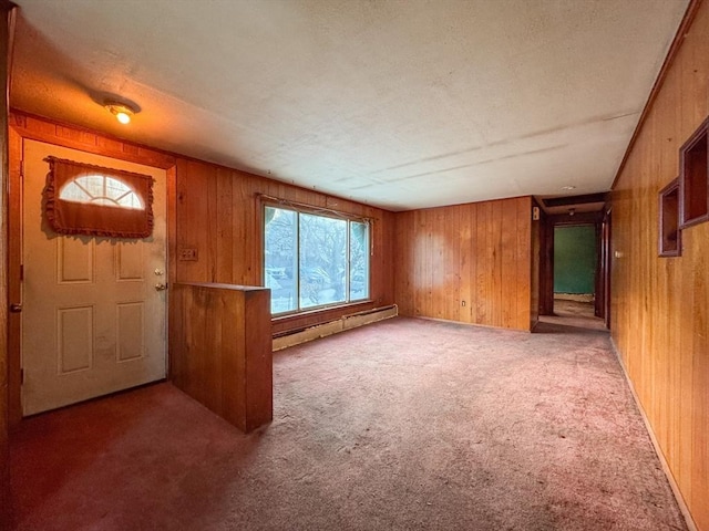 carpeted entrance foyer with baseboard heating and wood walls