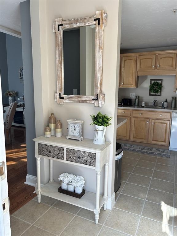 882 Brockton Ave Unit 10, Abington, MA 02351 - kitchen with a sink, light tile patterned flooring, light countertops, dishwasher, and baseboards