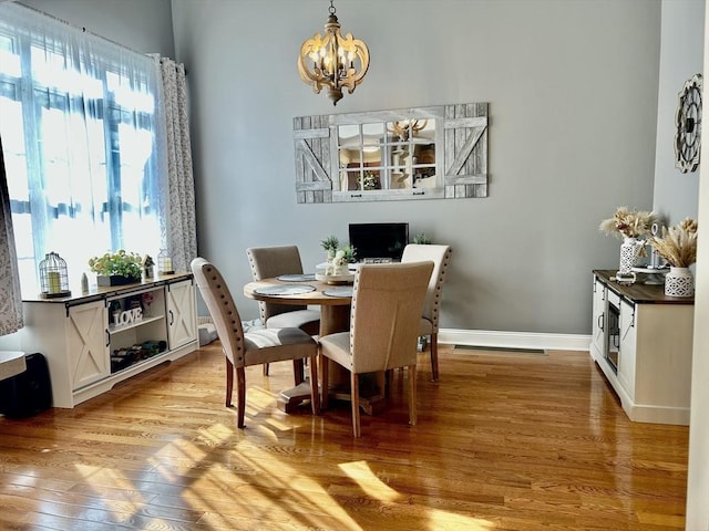882 Brockton Ave Unit 10, Abington, MA 02351 - dining area featuring a chandelier, light wood finished floors, and baseboards