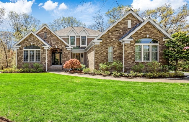 view of front of house featuring brick siding and a front lawn