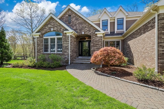 view of front of home with brick siding and a front yard