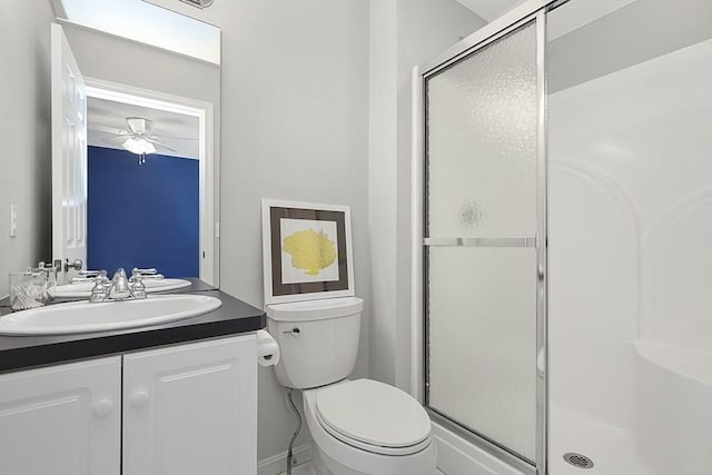 bathroom with toilet, ceiling fan, a shower stall, and vanity