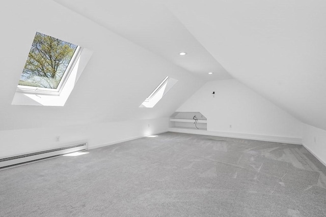 additional living space featuring vaulted ceiling with skylight, carpet flooring, recessed lighting, and a baseboard heating unit