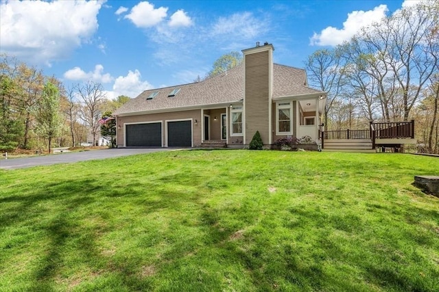 view of front facade featuring a garage, a deck, a front yard, a chimney, and driveway