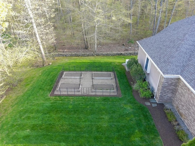 view of yard featuring a tennis court and fence