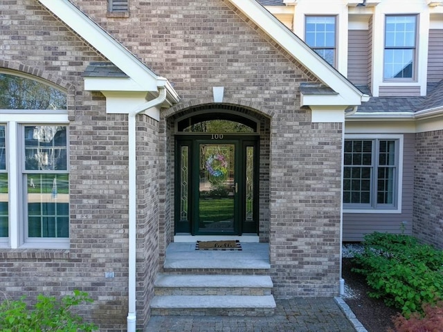 doorway to property with brick siding