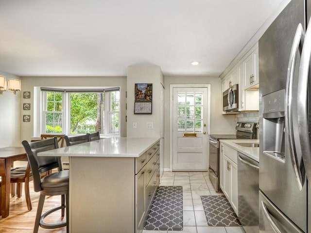 50 Lake St Unit B, Winchester, MA 01890 - kitchen with appliances with stainless steel finishes, healthy amount of natural light, a breakfast bar, light countertops, and recessed lighting