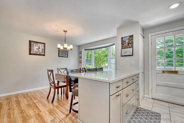 50 Lake St Unit B, Winchester, MA 01890 - kitchen with light countertops, a chandelier, a kitchen breakfast bar, decorative light fixtures, and white cabinets