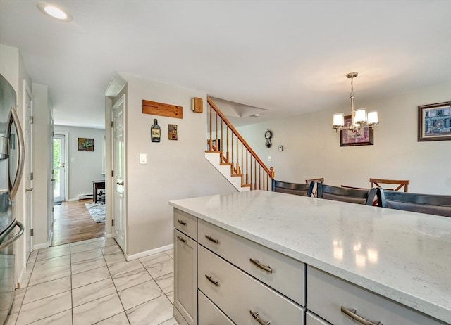 50 Lake St Unit B, Winchester, MA 01890 - kitchen featuring freestanding refrigerator, decorative light fixtures, light stone counters, a chandelier, and light marble finish floors