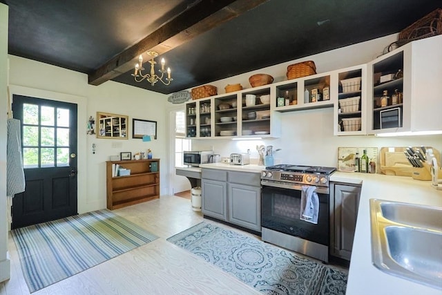 193 Main St, Medway, MA 02053 - kitchen featuring appliances with stainless steel finishes, open shelves, beamed ceiling, light countertops, and a chandelier