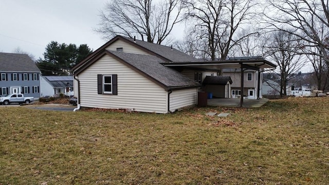 rear view of property featuring a carport and a lawn