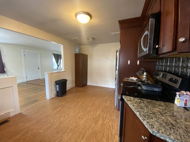 kitchen featuring light stone counters, appliances with stainless steel finishes, and light wood-type flooring