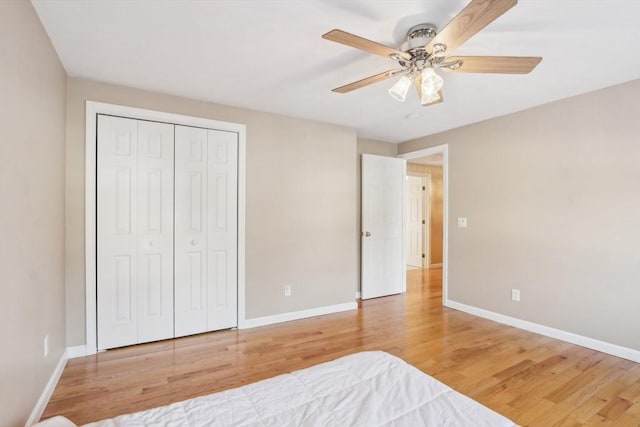 unfurnished bedroom with ceiling fan, a closet, and hardwood / wood-style floors