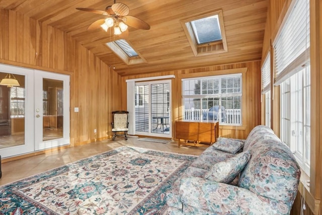 sunroom / solarium featuring ceiling fan, french doors, lofted ceiling with skylight, and wooden ceiling