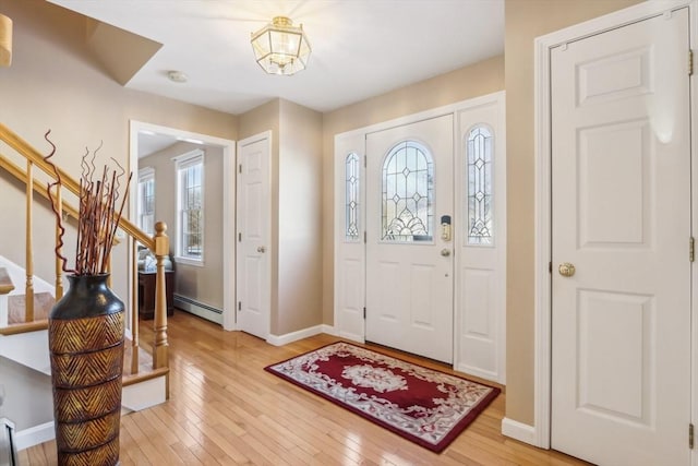 foyer entrance with wood-type flooring and a baseboard radiator