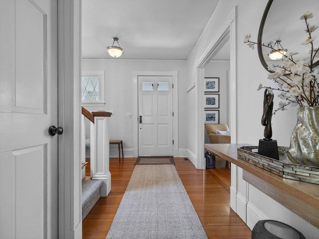 foyer featuring baseboards and dark wood-style floors