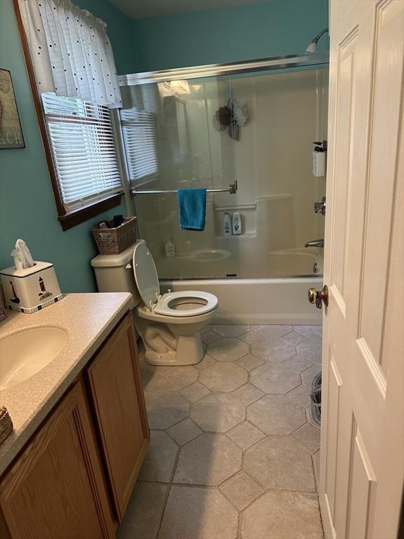 37 Teaberry Ln, Gardner, MA 01440 - bathroom featuring vanity, toilet, tile patterned floors, and shower / bath combination with glass door