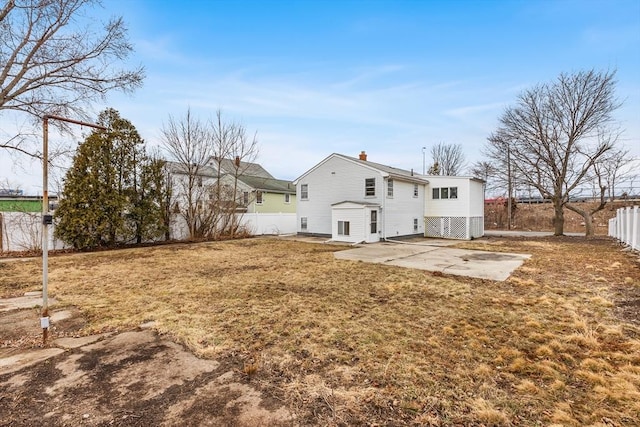 back of property with a patio area, a fenced backyard, a lawn, and a chimney