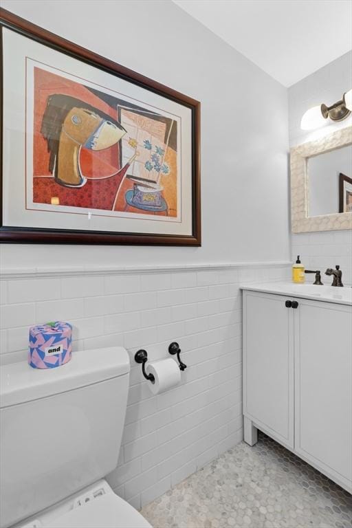 bathroom featuring tile walls, vanity, and toilet