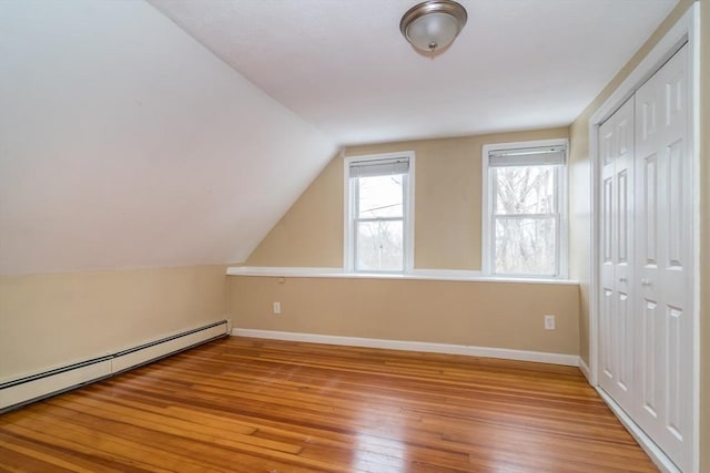 bonus room with lofted ceiling, baseboard heating, and hardwood / wood-style floors