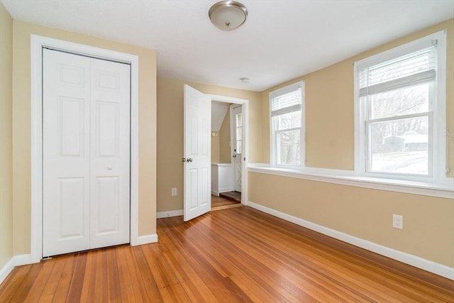 unfurnished bedroom with a closet and wood-type flooring