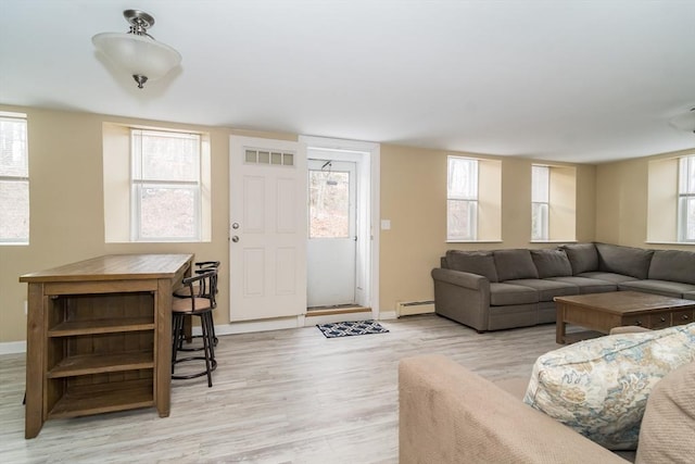 living room featuring a baseboard heating unit and light hardwood / wood-style flooring