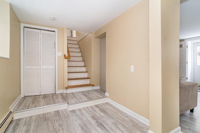 staircase featuring a baseboard radiator and hardwood / wood-style floors