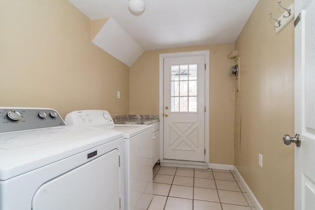 laundry area with independent washer and dryer, cabinets, and light tile patterned floors