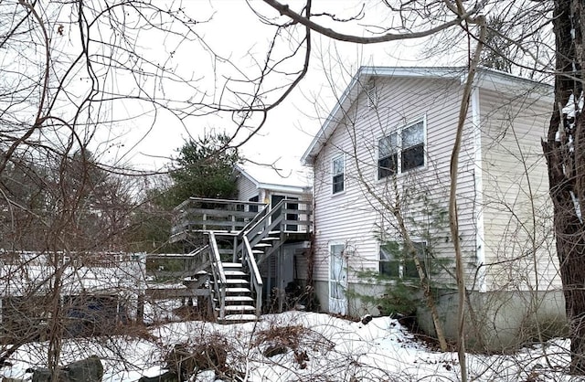 view of snowy exterior with a wooden deck