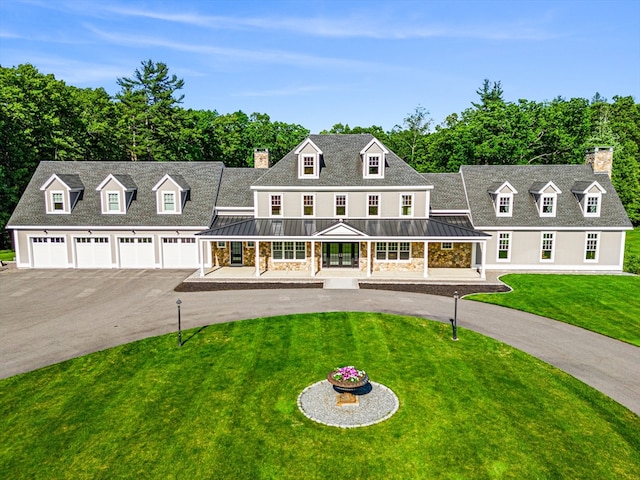 new england style home with a front lawn, a garage, and covered porch